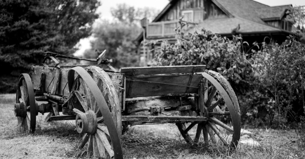 Old wooden cart in rural setting by a rustic farmhouse, exuding vintage charm.